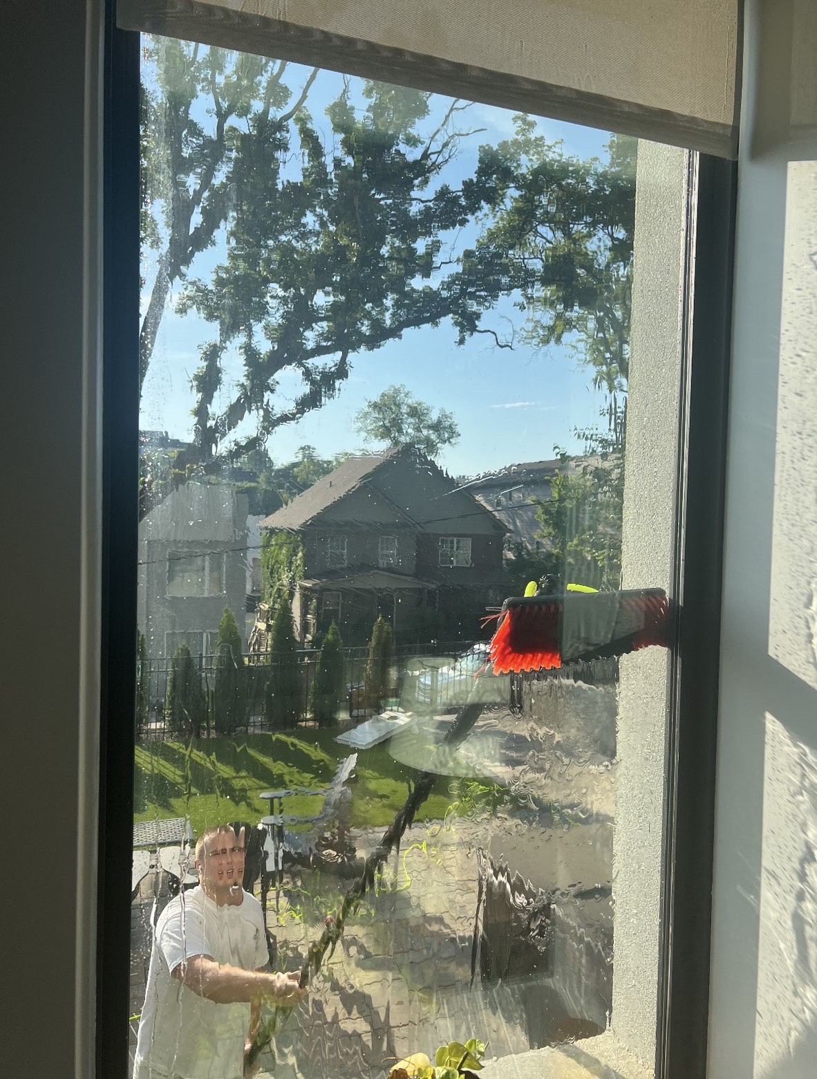 Water-fed pole brush cleaning a second-story window